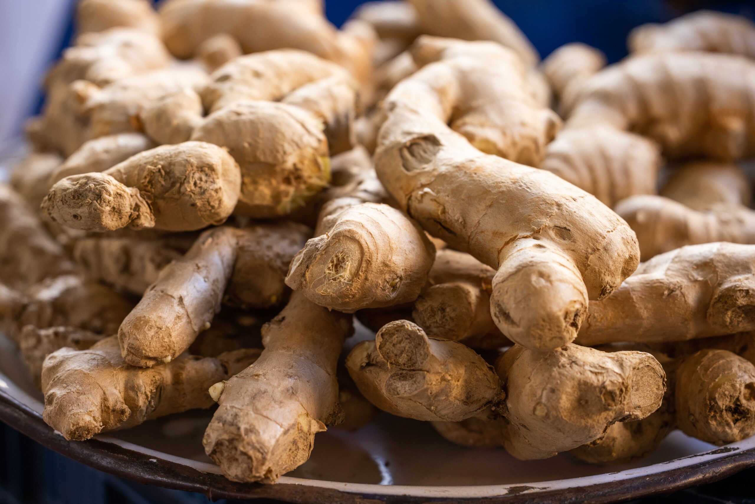 Indian spices A close-up photo of fresh, raw ginger roots piled on a plate. Perfect for culinary use.