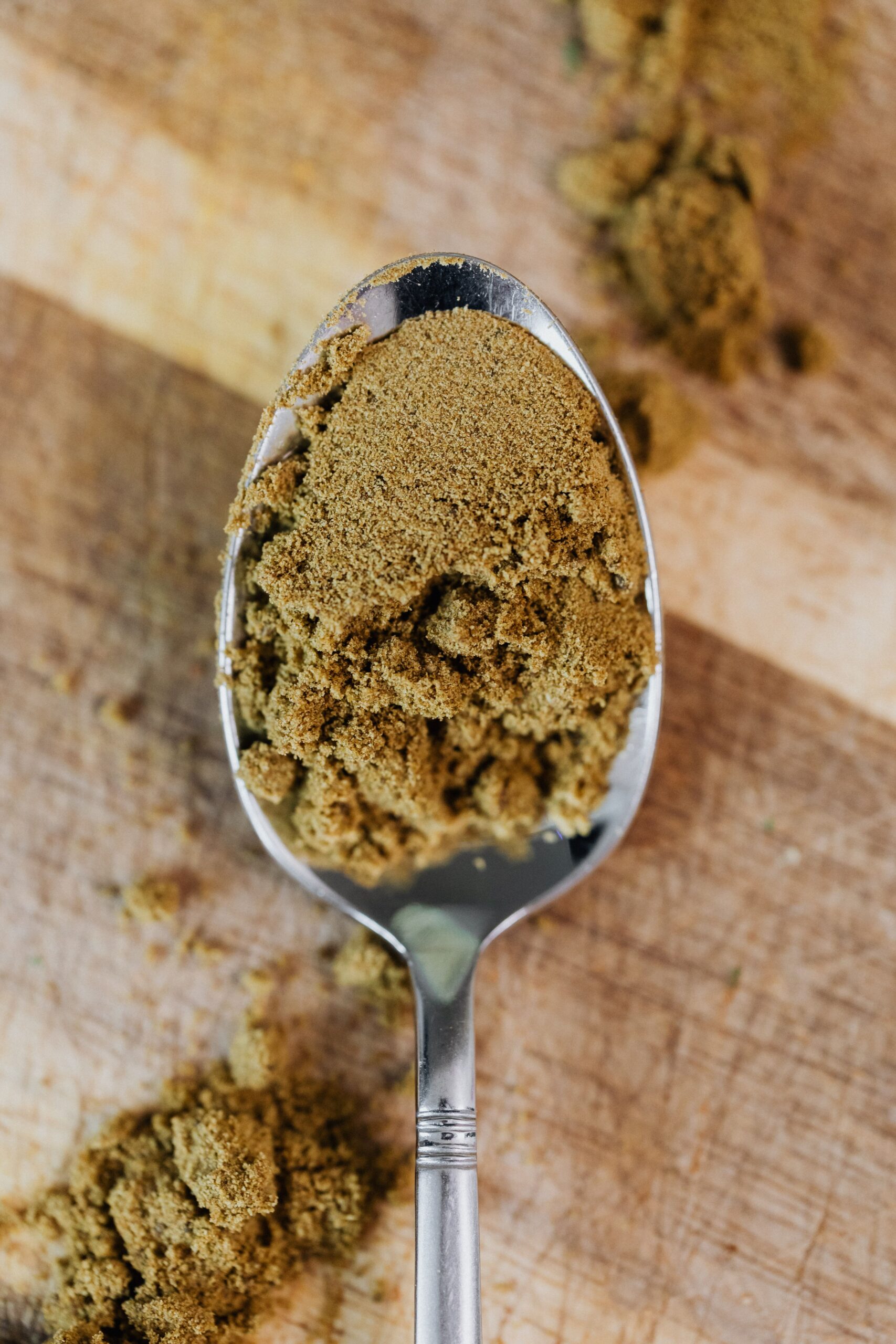 Indian spices A detailed close-up of ground cumin on a spoon, showcasing its texture.